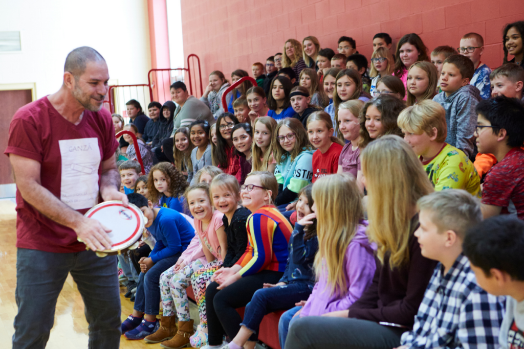 Paulo Padilha demonstrates how to play the pandeiro for a group of Rushville students.